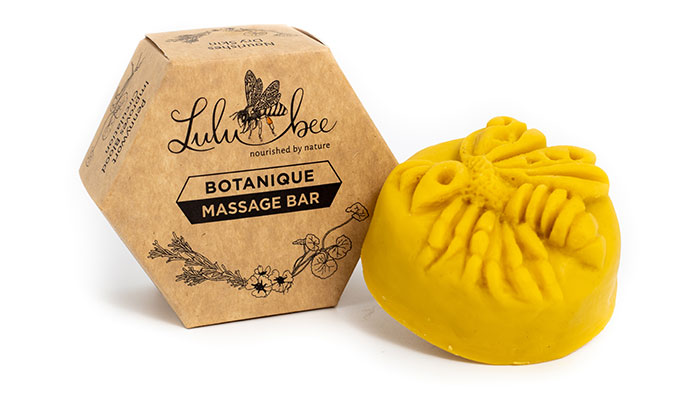 massage lotion bar next to its hexagonal packaging box